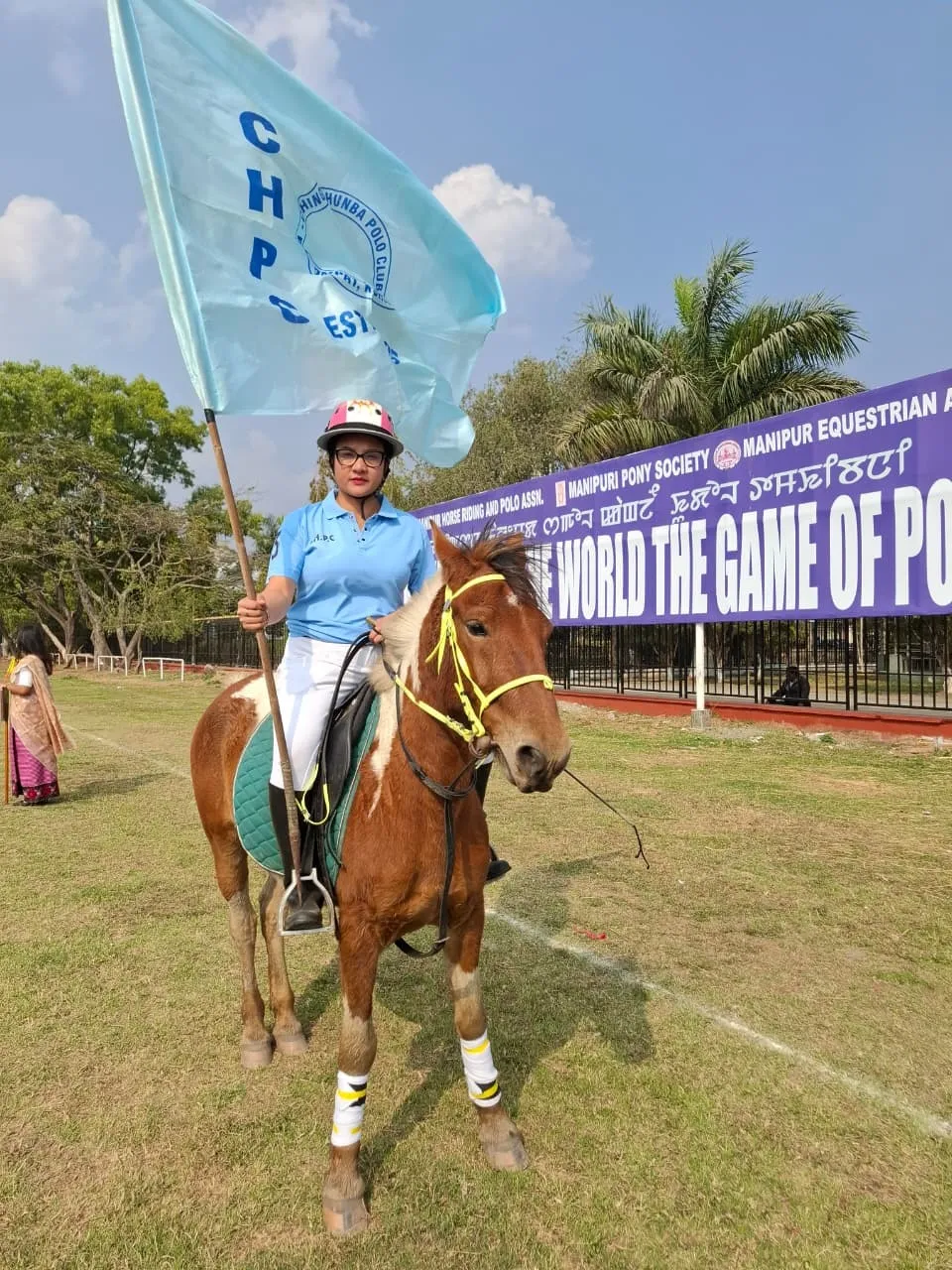 Thoudam Tanna, captain of the women’s side, with the club flag at Mapal Kangjeibung.
