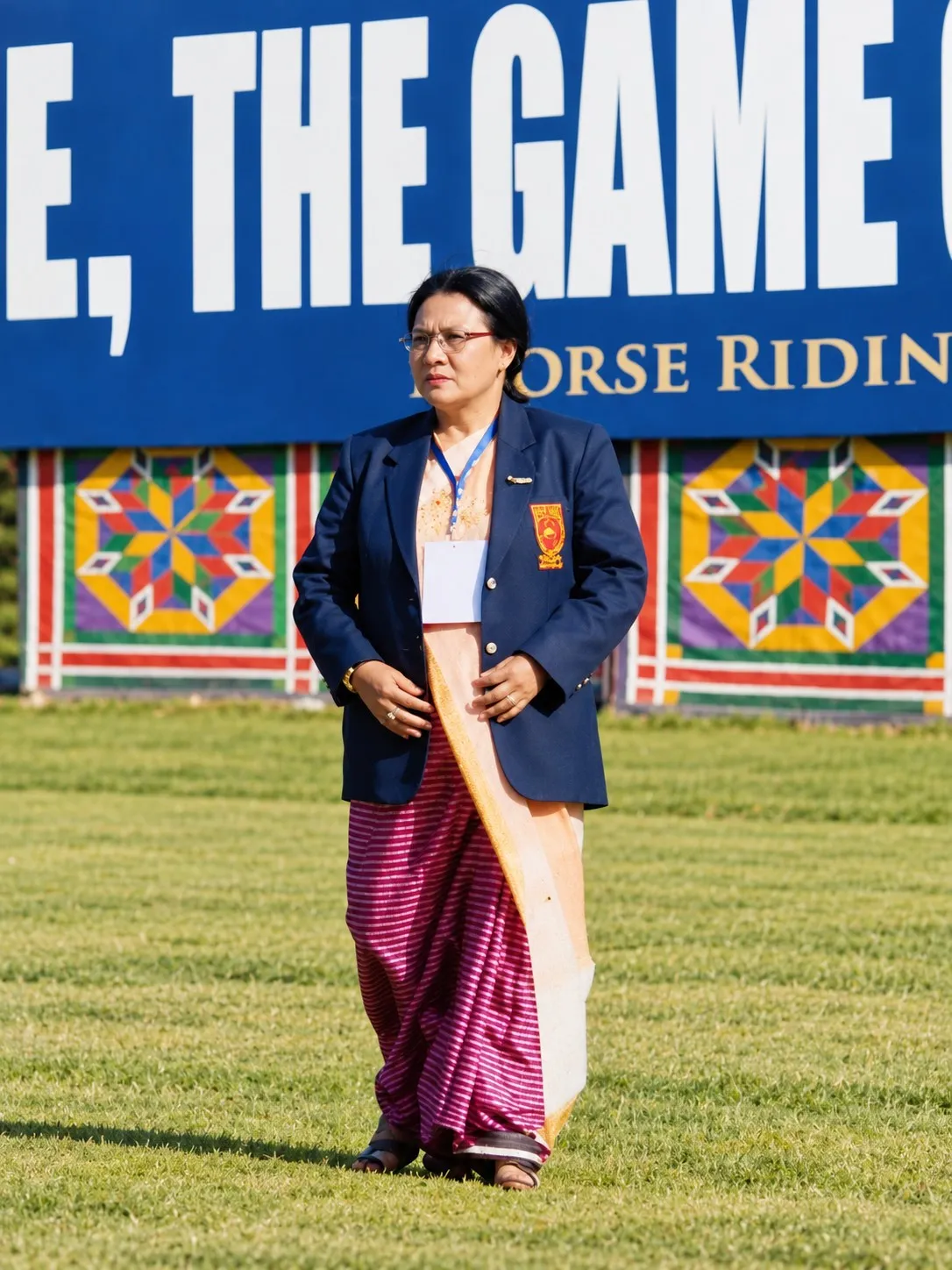 Thoudam Thoinu Devi, President of Chingkhei Hunba Polo Club, standing on a polo ground in a navy blazer